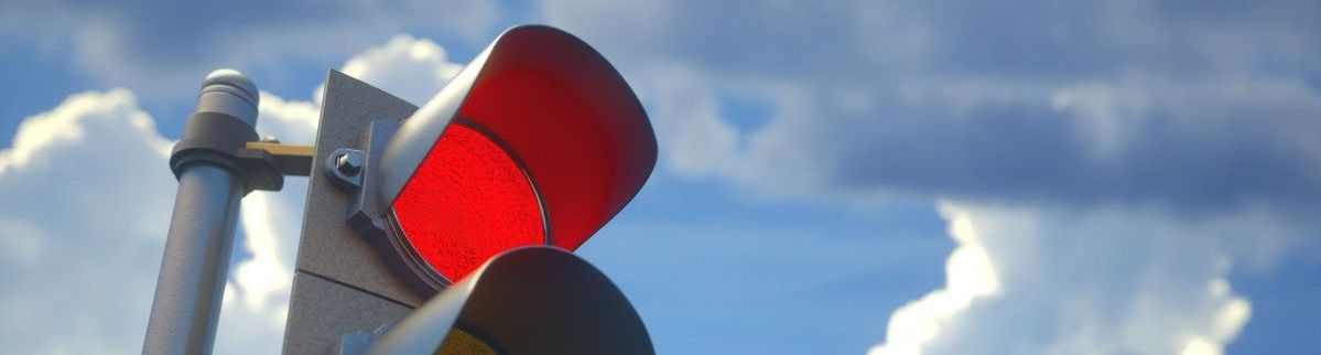 En trafikljus som lyser rött med blå himmel som bakgrund.
